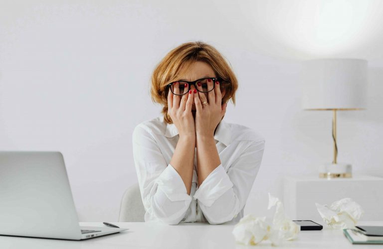 Persona usando su computadora con estrés laboral